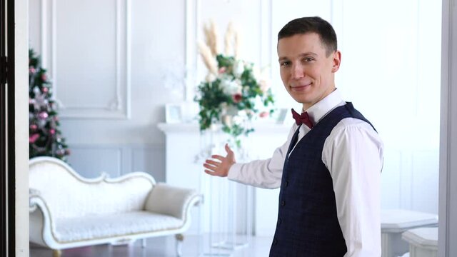 Man opening double wooden door and inviting people to come in new place.