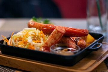 fried sausages and sauerkraut in a black cast iron pan.