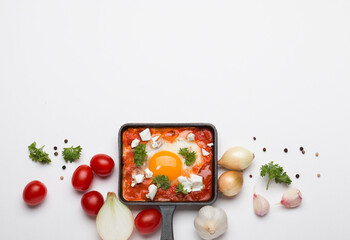 Fried eggs with tomatoes and cheese in a frying pan. Shakshuka, a Jewish dish.
