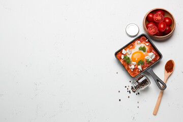 Fried eggs with tomatoes and cheese in a frying pan. Shakshuka, a Jewish dish.
