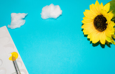 Paint brush and sunflower with blue background. Cotton wool. Minimal concept. Back to school.