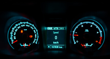 car speedometer that shows details of the car, speed, distance, etc., on a dark background.