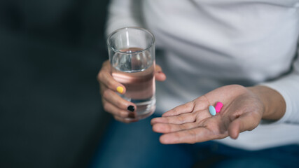 close-up of a woman's hand holding water and medicine health care concept