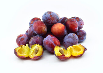 Fresh purple plum and halfs isolated on white background.