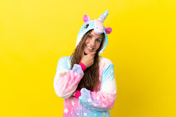 Girl with unicorn pajamas over isolated background smiling