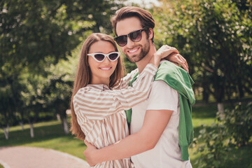 Photo portriat young couple smiling cuddling together having romantic date in green park