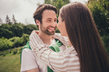 Photo portriat young couple smiling hugging each other walking in green city park