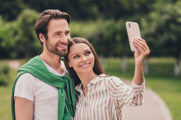 Photo of young attractive couple happy positive smile boyfriend girlfriend hug make selfie cellphone outdoors