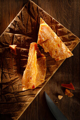 Pieces of aged cheese on a wooden Board with a knife. Italian hard cheese still life, top view. High resolution. 