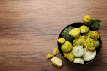 Fresh ripe pattypan squashes on wooden table, flat lay. Space for text