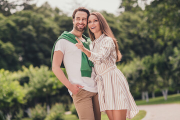 Fototapeta premium Photo of young cheerful couple happy positive smile girl point indicate finger curious interested cuddle walk outdoors