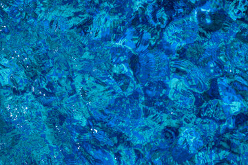 Solar glare on the water in the pool. Blue surface water background