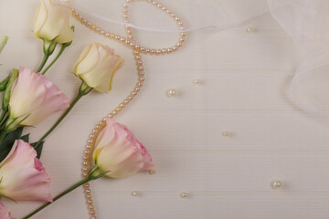 Wedding postcard. Eustoma flowers, delicate veil and beads on light background