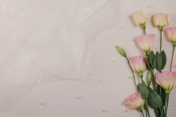 Delicate eustoma flowers on light background decorated with a wedding veil
