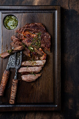 Slices of steak on dark wooden board
