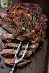 Slices of steak on dark wooden board