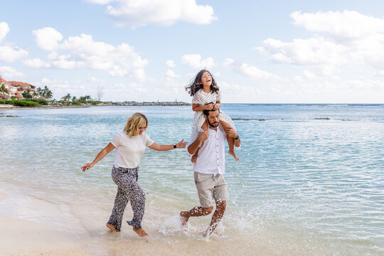 Familia multiracial jugando en las playas de Canc&uacute;n, M&eacute;xico