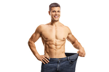 Fototapeta premium Shirtless young man wearing a pair of big size jeans