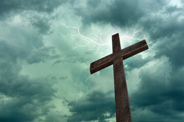 Religious cross against lightning and parting clouds