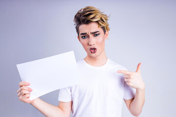 asian man with luxurious blonde hair and gorgeous make-up holding mock up board in white wall studio background
