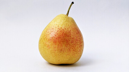 yellow pear with red speckles on a white background
