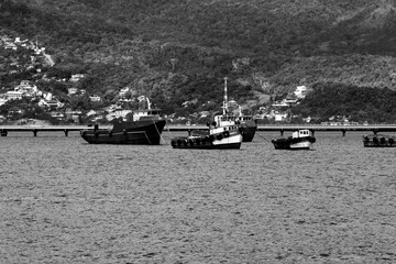 Mar de Ilha Bela ao fundo a serra e sobre a água barcos de de pesca.