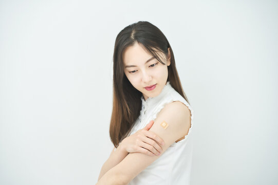 ワクチン接種のパッチが貼られた女性の腕
