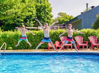 Childrens playing in pool on summer time jumping