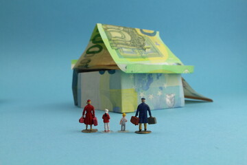 Haus aus Geldscheinen mit einer Familie im Vordergrund 