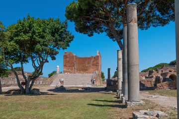 The Capitolium at archaeological excavations of Ostia Antica surrounded by ruins, columns and remains of statues and bas-reliefs