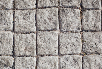 background of gray stone paving slabs in sunlight