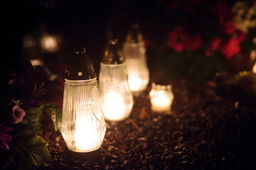 Candles lit up on All Souls Day in Lithuania. Candle flames illuminating a cemetery during All...