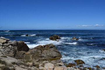 Fototapeta na wymiar The ocean meeting the rocky shore at 17 Mile Drive in Monterey, California.