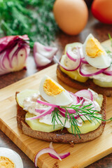 Smorrebrod. A sandwich of rye bread with herring, potatoes, egg, red onion, dill and horseradish or mustard sauce. Toast with salted fish. Scandinavian cuisine. Selective focus