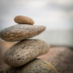 Fototapeta na wymiar Zen rocks piled on top of each other on blurred ocean and sky background