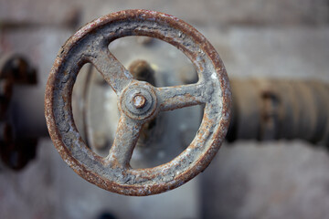 Industrial pipeline and valve close up, blur background. Old rusty control equipment, abandoned plant industry refinery.