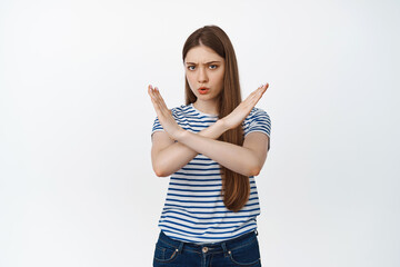 Serious frowning girl showing cross sign, stop prohibit gesture, forbid something bad, no...