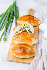 Delicious little pies with green onion and egg. Traditional Russian cuisine. Homemade cakes. © Marika