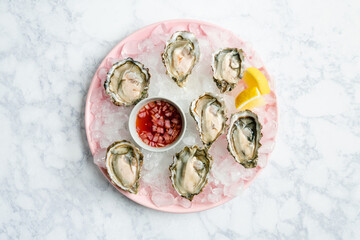 Overhead view of fresh oysters on a plate with mignonette - Powered by Adobe