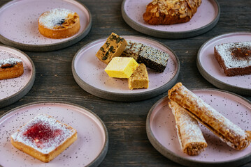 various desserts in plates placed on a wooden table.