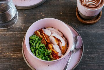 rice with chicken, herbs in a bowl on a wooden table