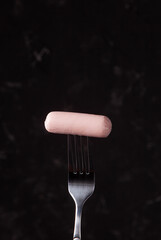 sausage on a fork dark background