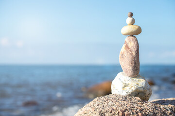 stack of stones on beach with sun light