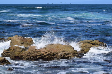 Ocean waves splashing onto some rocks at 17 Mile Drive in Monterey, California.