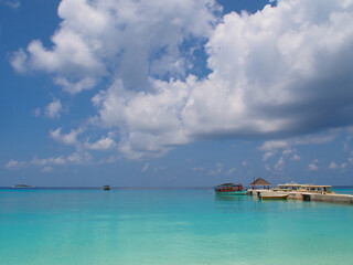 Blue water and blue sky with clouds on the horizon of the Indian Ocean in the Maldives. Copy space for text.