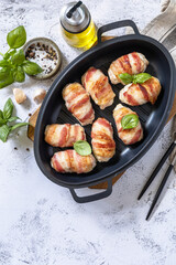 A festive dish. Baked chicken fillet with ricotta in bacon on a stone table top. Top view flat lay background. Copy space.