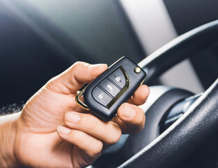 Car keyless entry remote in the owner hand on the car