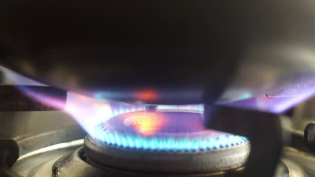 close up shot of natural petroleum cooking gas burner with a blue red flame used in India for cooking food and heating items given by companies like Indian Oil corporation, Indraprastha Gas limited