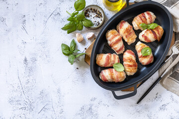 A festive dish. Baked chicken fillet with ricotta in bacon on a stone table top. Top view flat lay background. Copy space.