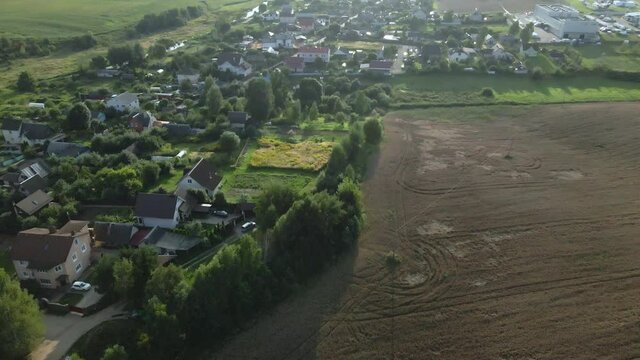 A small village surrounded by agricultural fields.  Filmed at sunset.  Aerial photography.